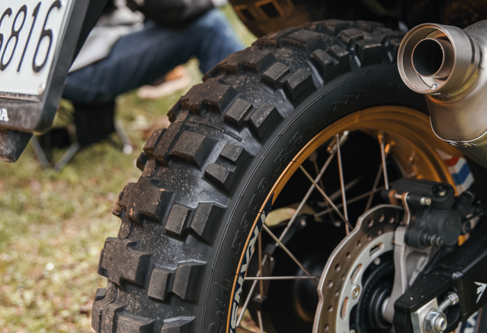 Primo piano dello pneumatico Dunlop D908RR con disegno del battistrada tassellato per utilizzo adventure e offroad.
